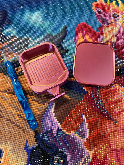 Deluxe 2 Phoenix small diamond painting tray in pink colorway with blue pen, shown on colorful diamond painting canvas.