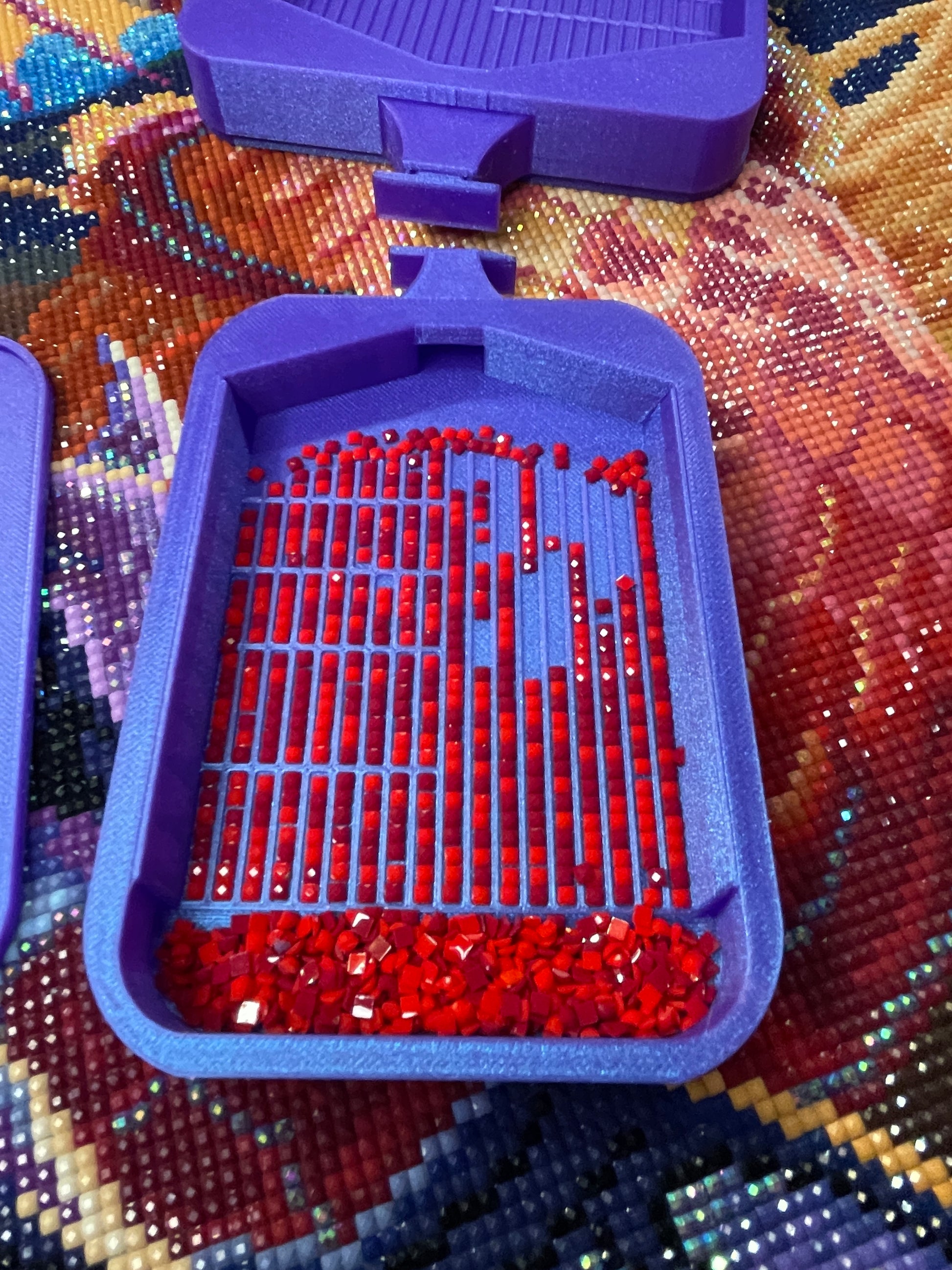 Purple diamond painting tray with red drills, featuring sloped walls and clip-on lid for easy multiplacing in artistic projects.