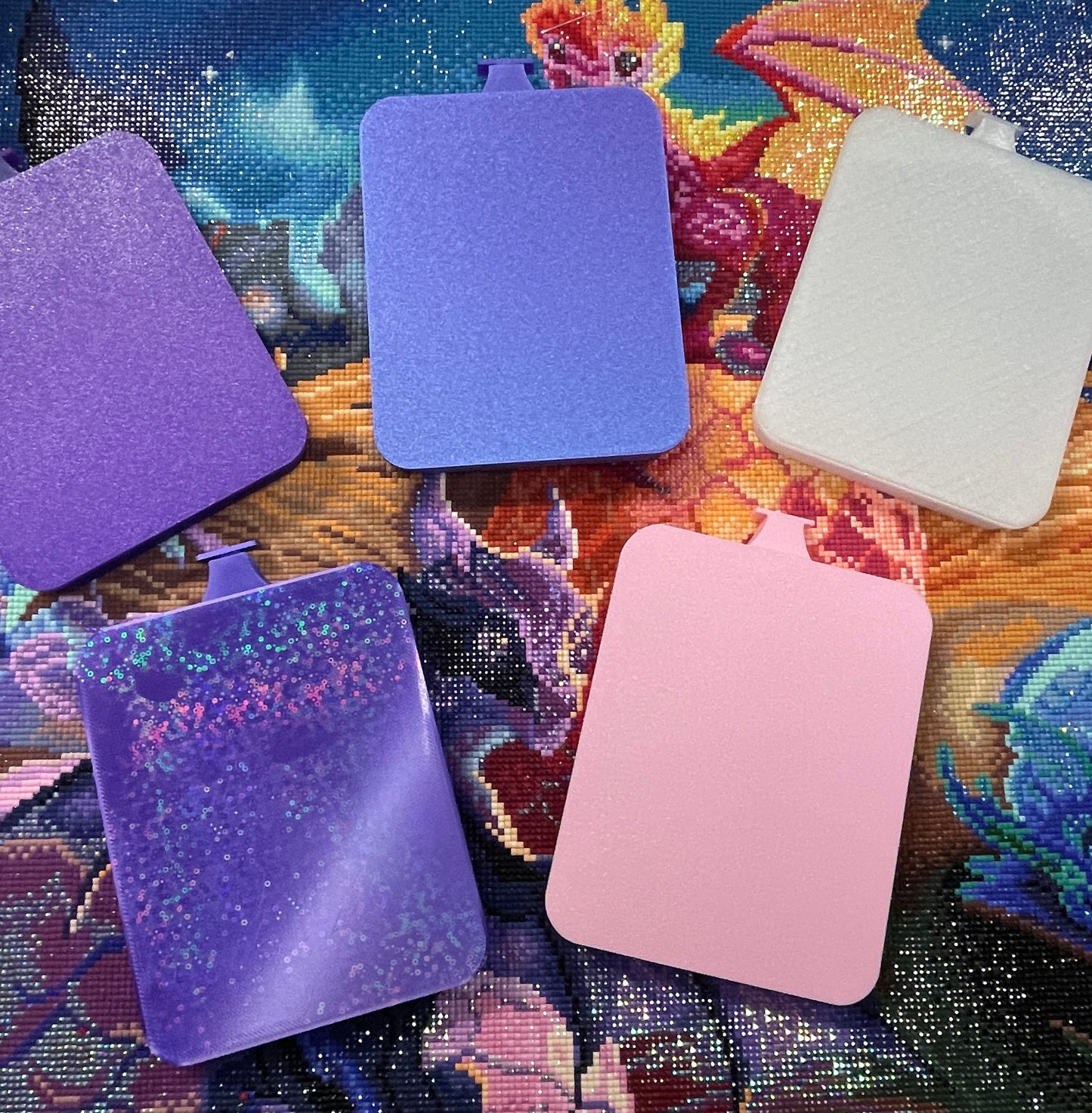 Colorful diamond painting trays with clip-on lids on a vibrant background.