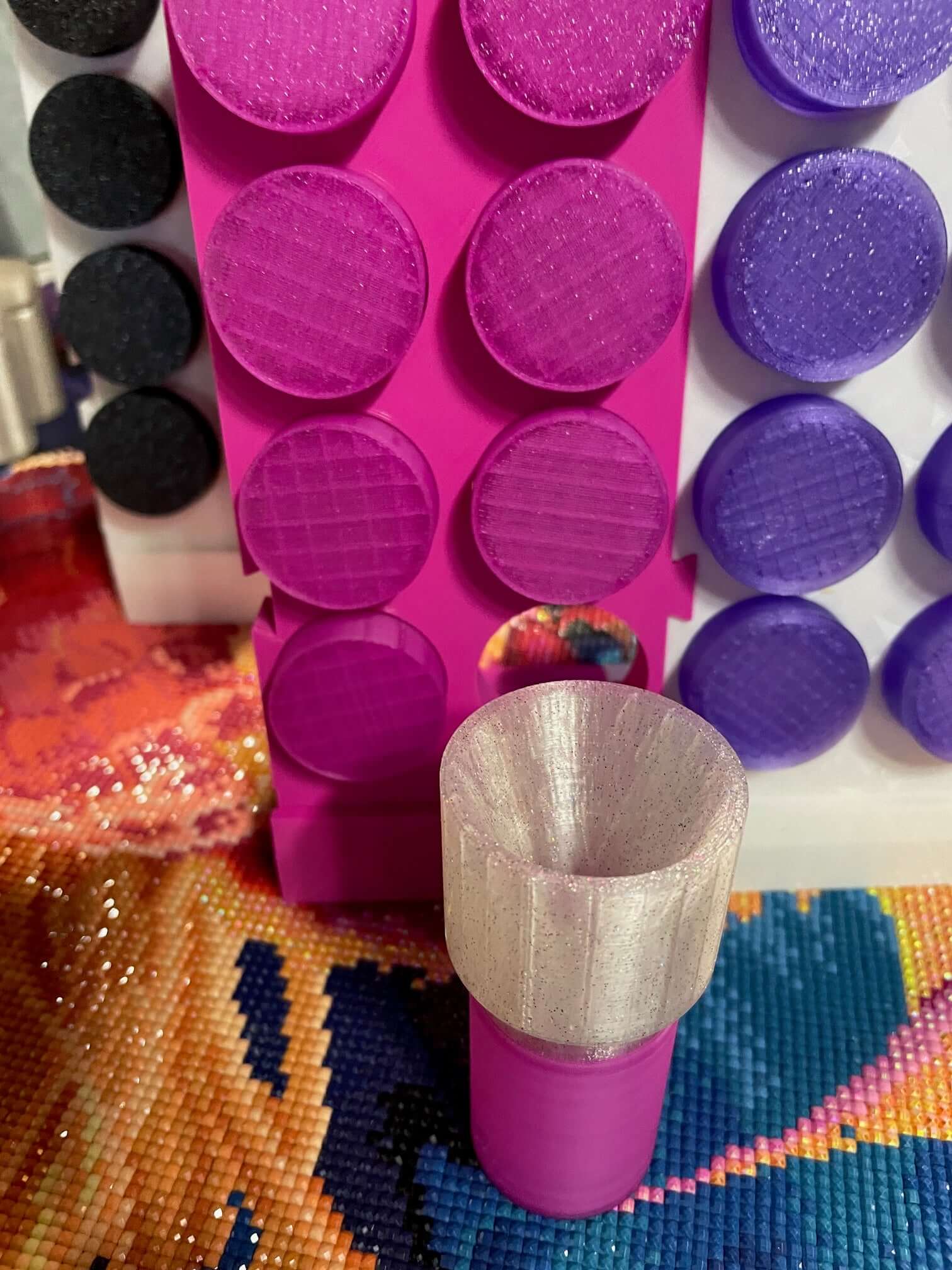 Pink and purple drill containers with a screw-on funnel on a colorful craft background.